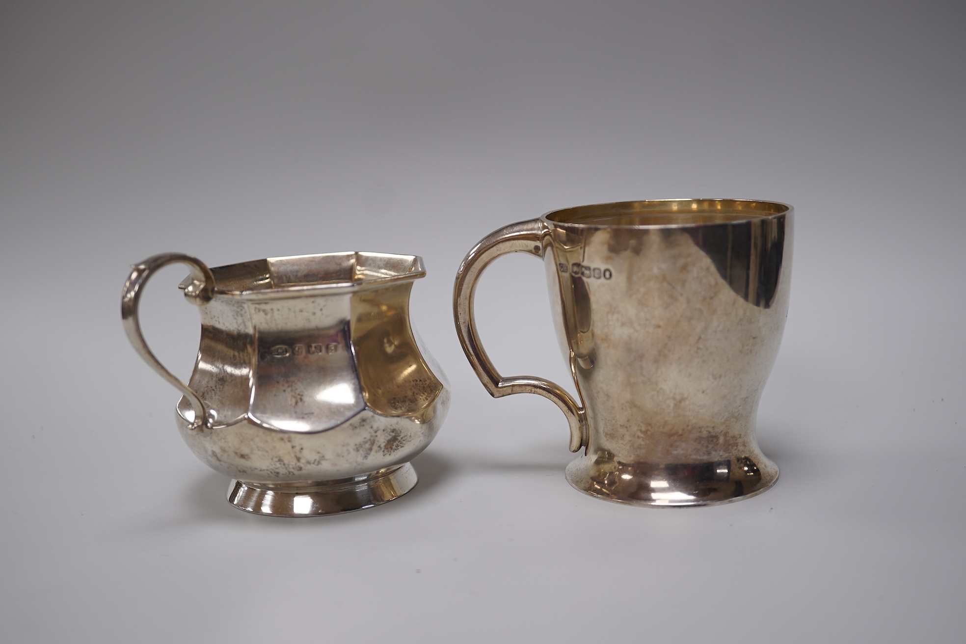 A George V silver christening mug, George Howson, Sheffield, 1934, height 77mm, together with one other silver mug, a small silver two handled cup, a silver salt and a small quantity of assorted silver flatware, 22.7oz.